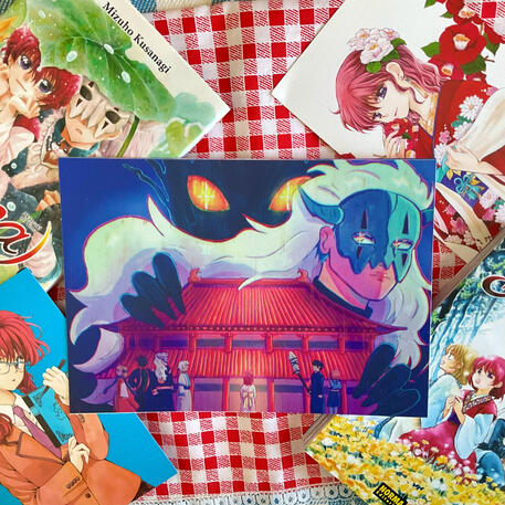 Foto de la print de Akatsuki no Yona. A modo de decoración a su alrededor hay: dos postales del manga y los volúmenes 6 y 34.