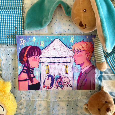 Foto de la print de Spy x Family. A modo de decoración a su alrededor hay: un pañuelo a cuadros azul, un peluche de un osito marrón, un peluche de un conejo azul y un peluche de Usagi de la serie Chiikawa.